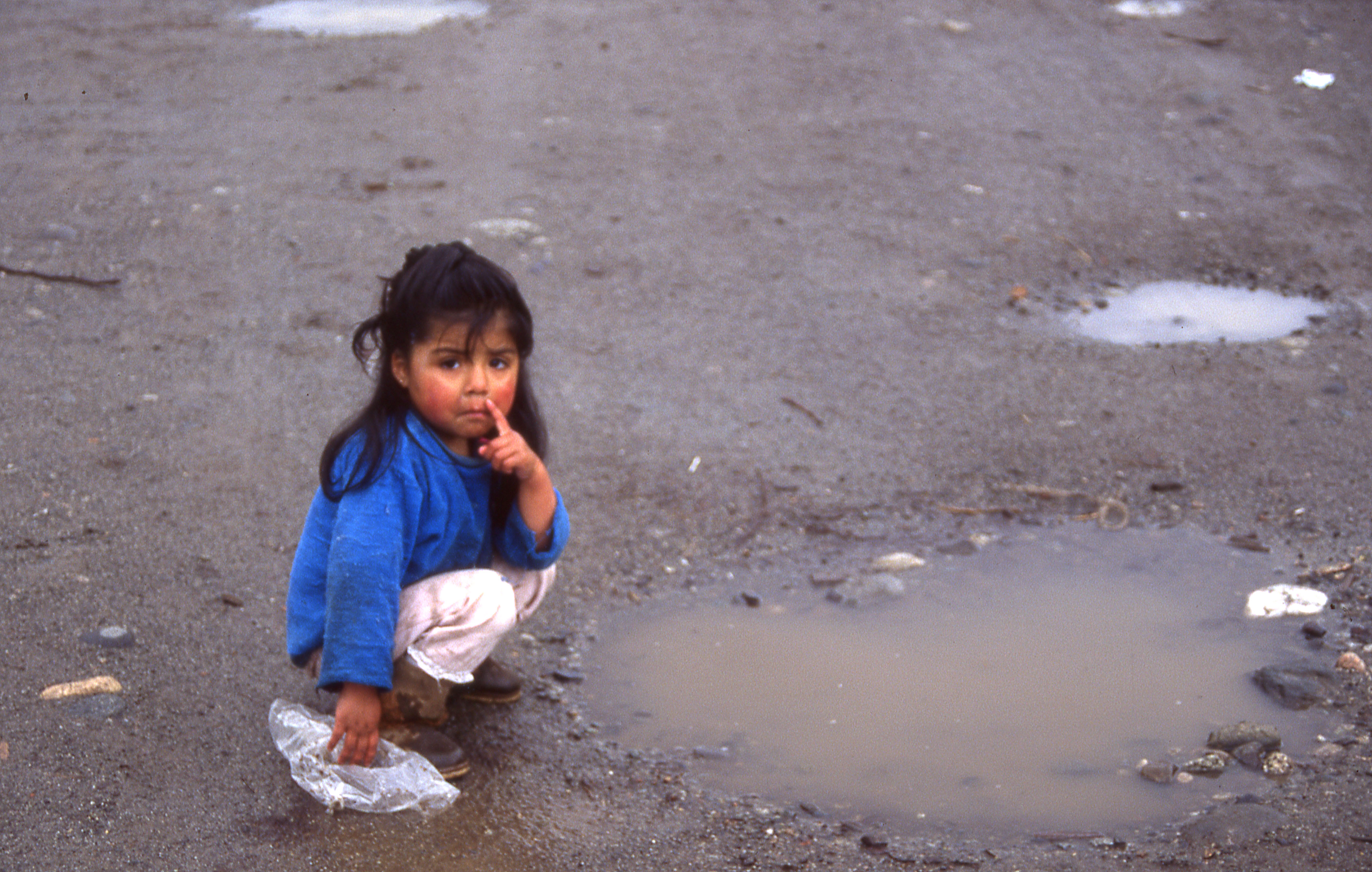 Niña juega en un charco de agua Niña juega en un charco de agua